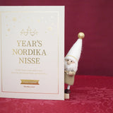 NORDIKA nisse イヤーズノルディカ2026 金色の文字入りBOOK型収納箱の横から顔をのぞかせるニッセ